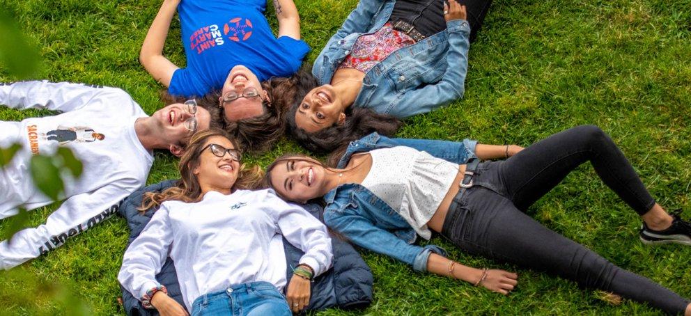 five students on grass in a circle